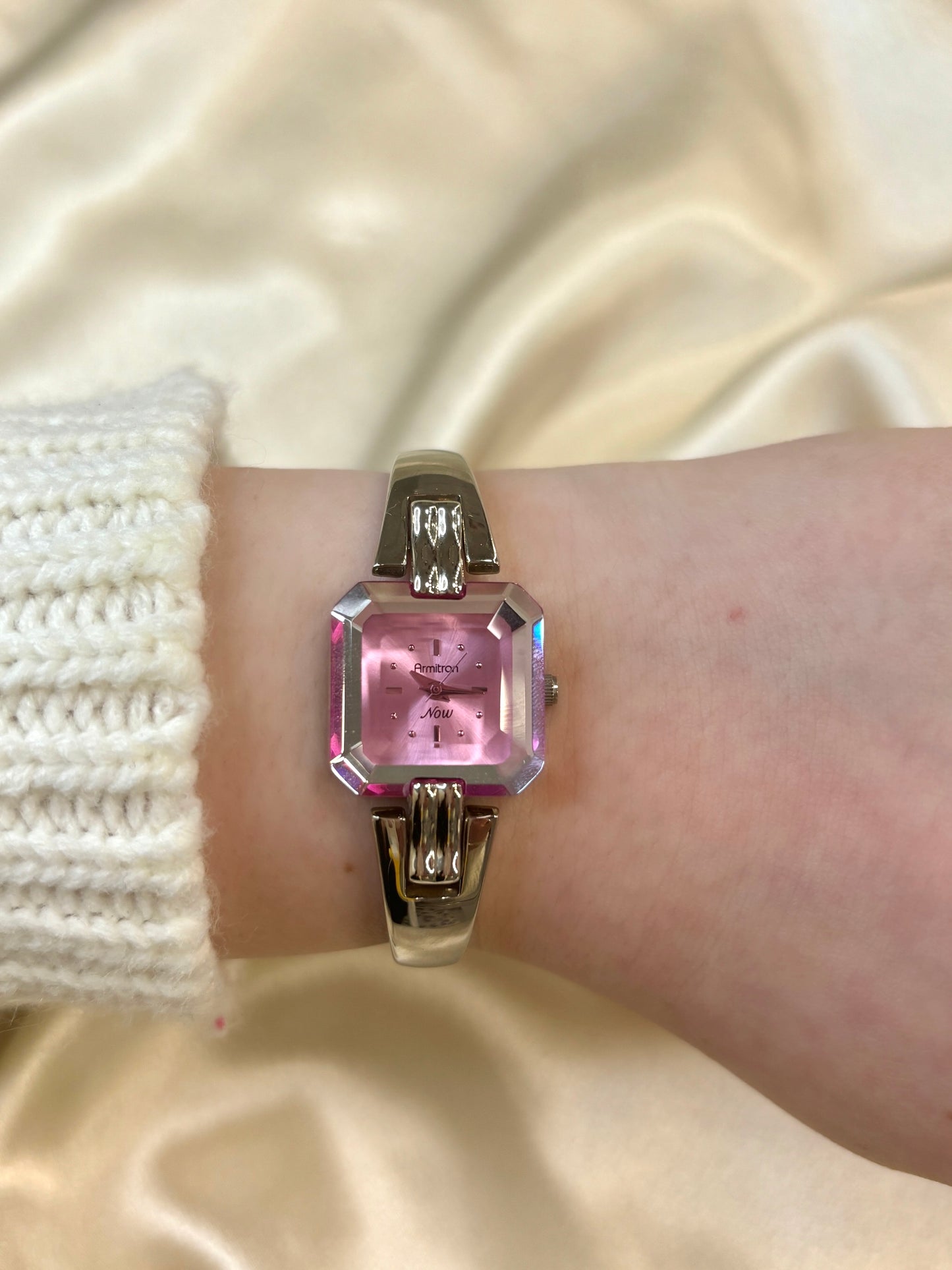 Reloj en tono plateado con esfera rosa